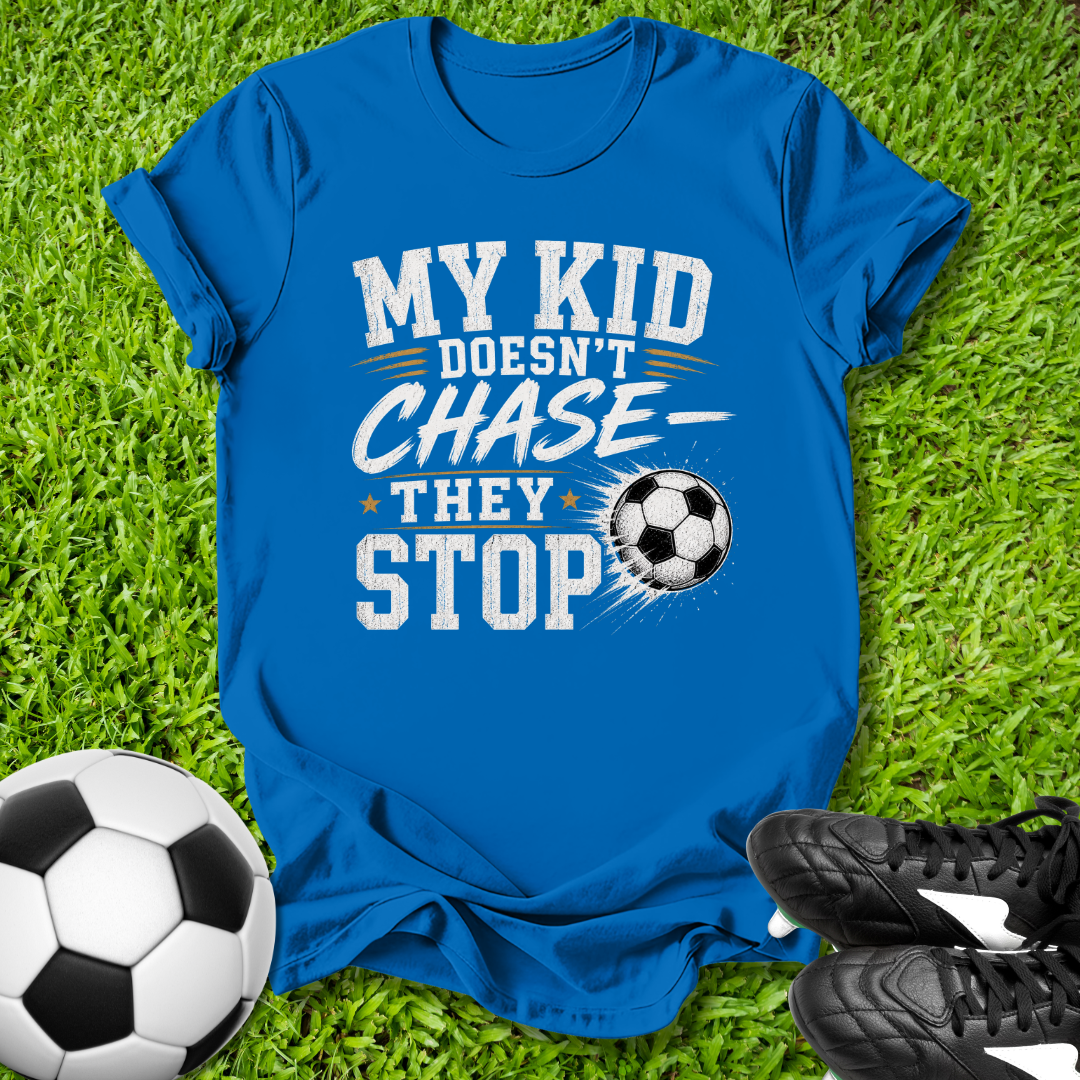 Blue shirt with a soccer ball that says in white text y Kid Doesn't Chase--They stop.