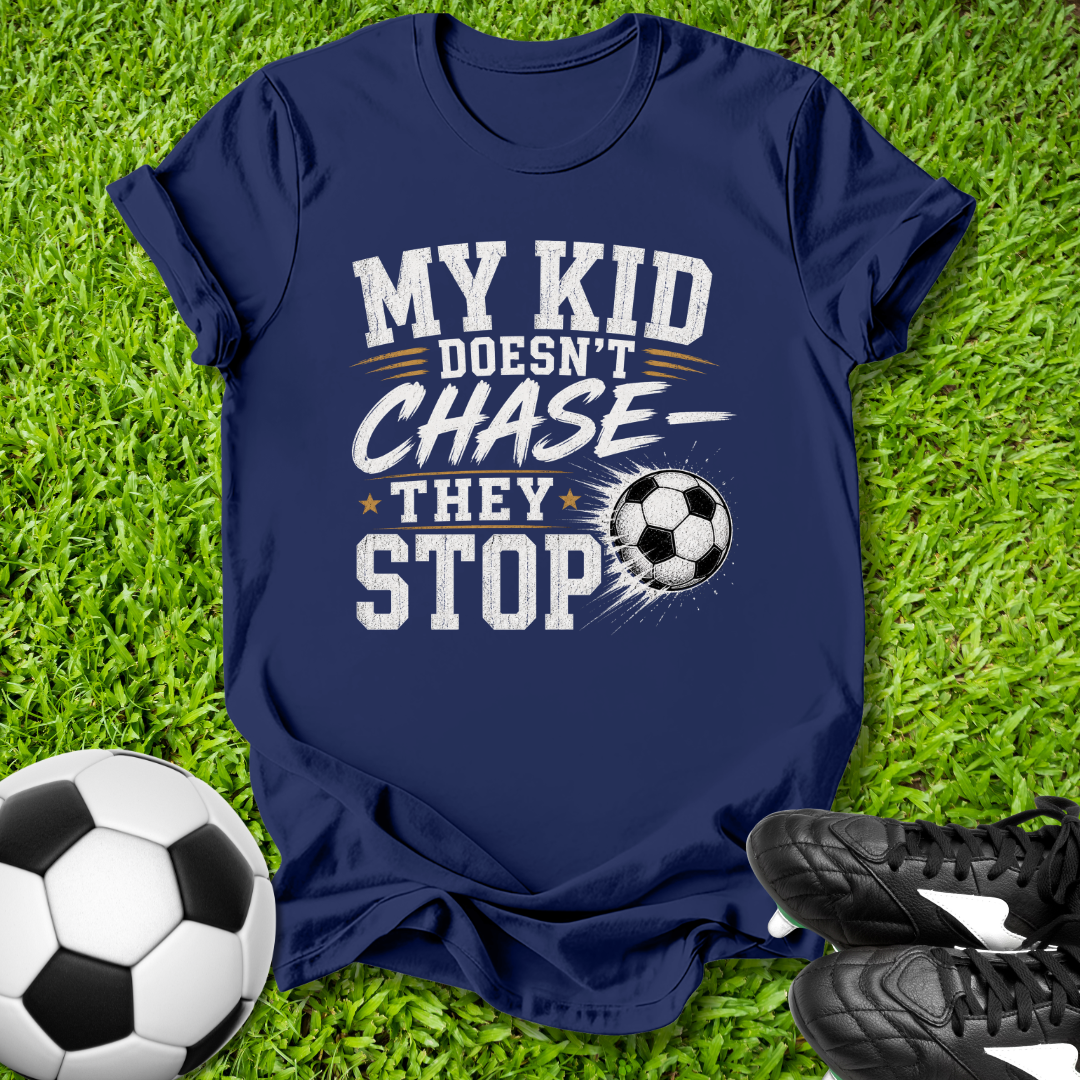 Navy blue  shirt with a soccer ball that says in white text y Kid Doesn't Chase--They stop.