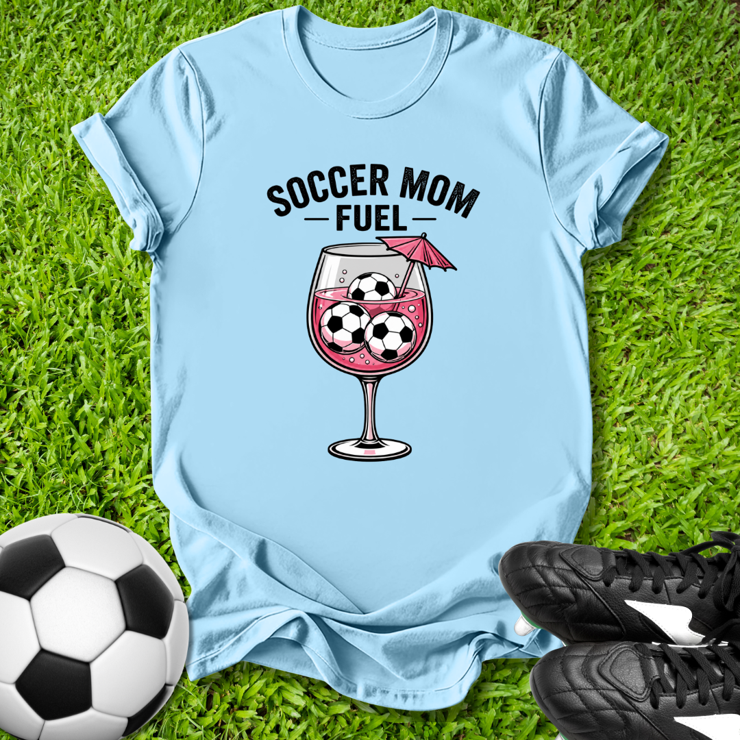Light blue t-shirt with 'Soccer Mom Fuel' graphic on grass with soccer ball and shoes.