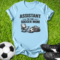 Light blue t-shirt with 'Assistant to the Soccer Mom' text and graphics on grass with soccer ball and shoes.