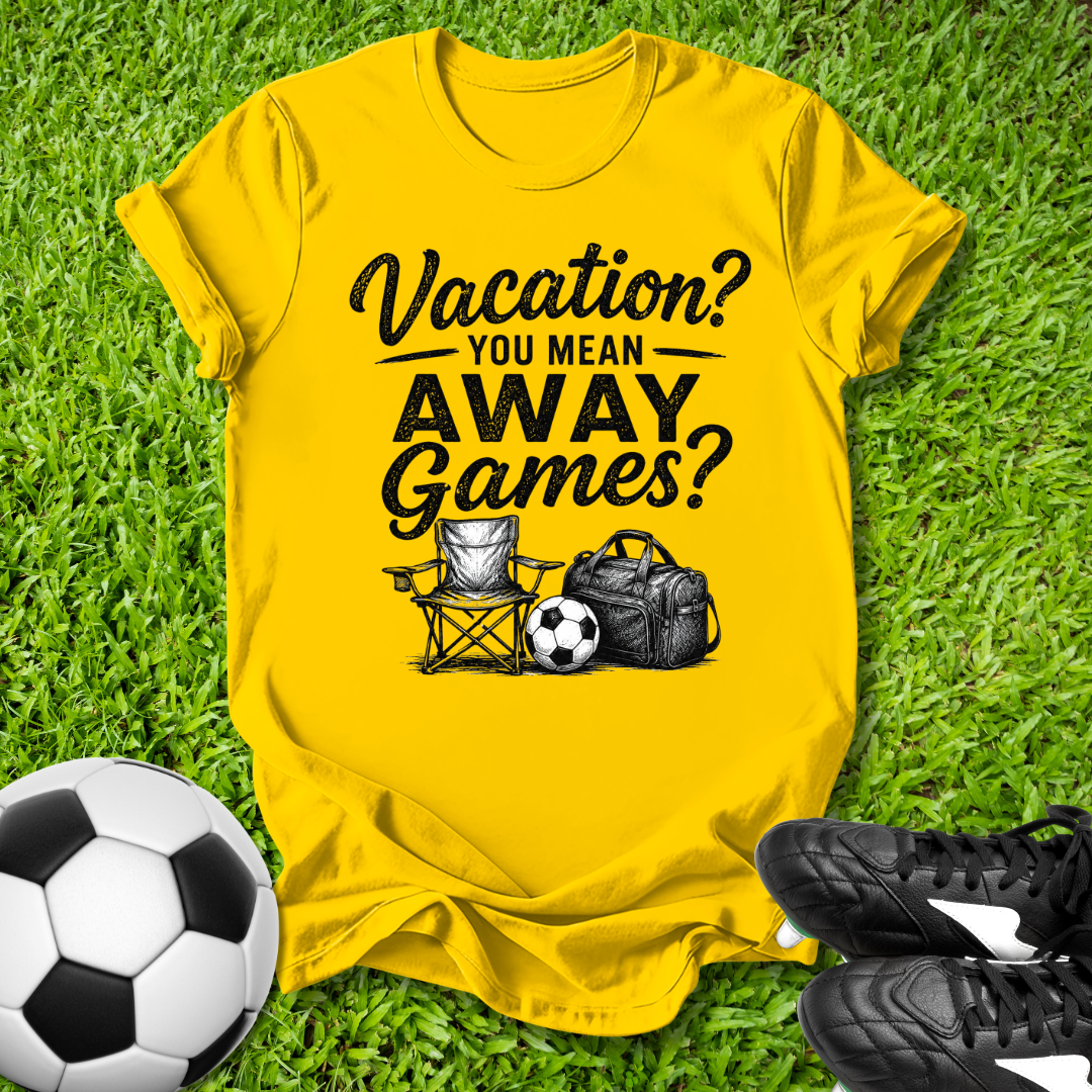 Yellow t-shirt with 'Vacation? You mean AWAY Games?' text on grass with soccer ball and shoes.