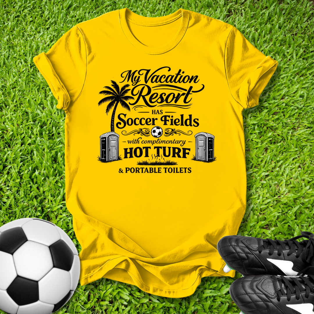 Yellow t-shirt with a humorous soccer field graphic on grass with a soccer ball and shoes.