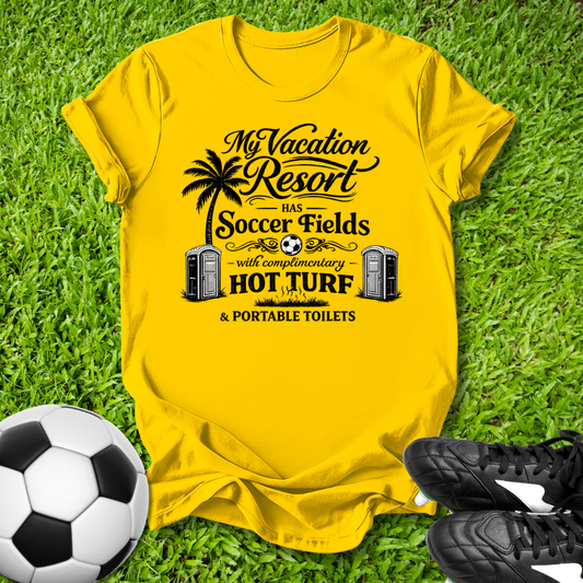 Yellow t-shirt with a humorous soccer field graphic on grass with a soccer ball and shoes.