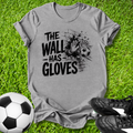 Gray t-shirt with 'The Wall Has Gloves' graphic on grass with soccer ball and shoes.