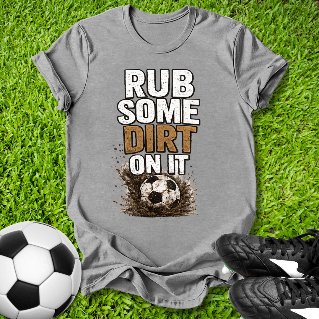 Gray  t-shirt with 'Rub some dirt on it' text on grass with soccer ball and shoes.