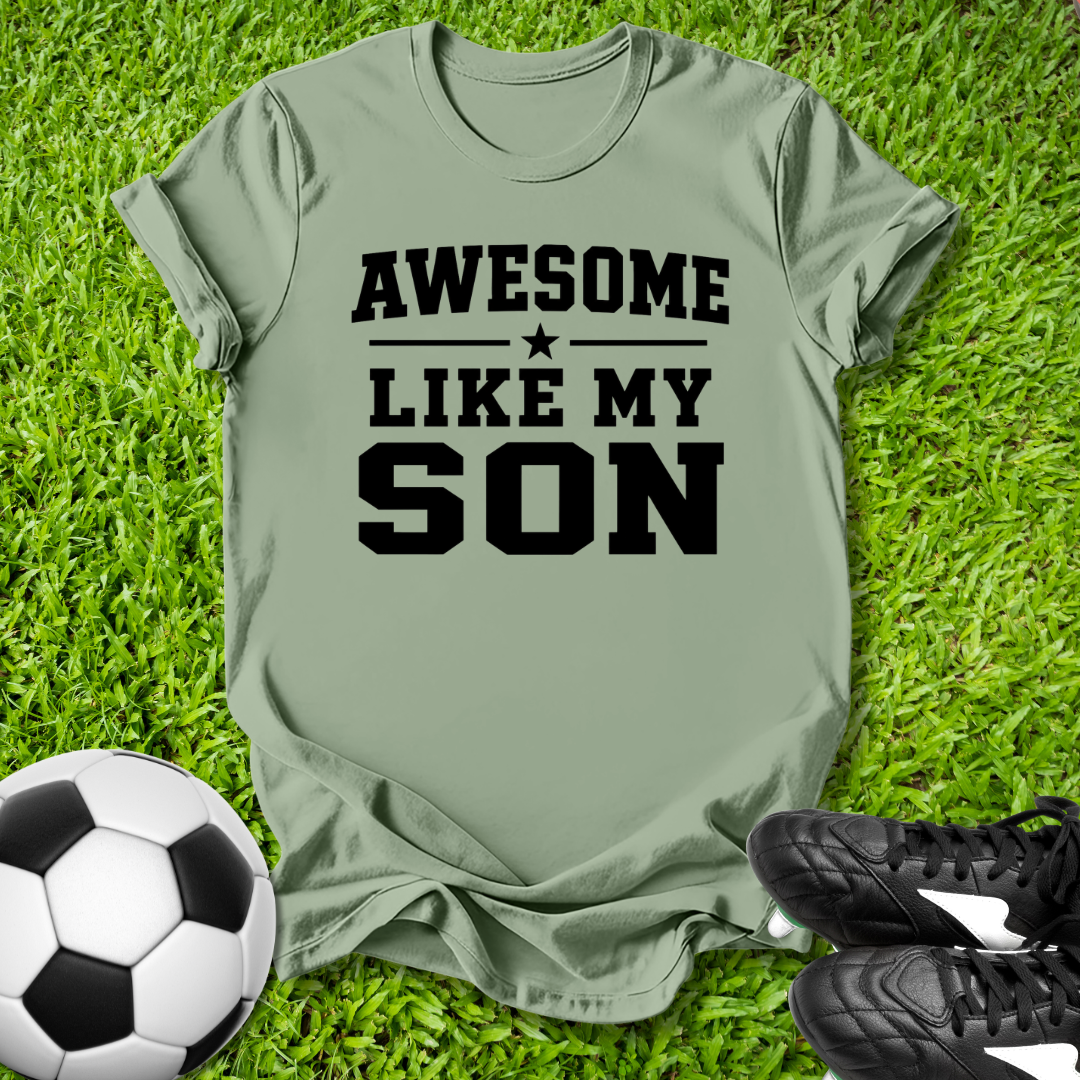 Green t-shirt with 'Awesome Like My Son' text on grass with soccer ball and shoes.