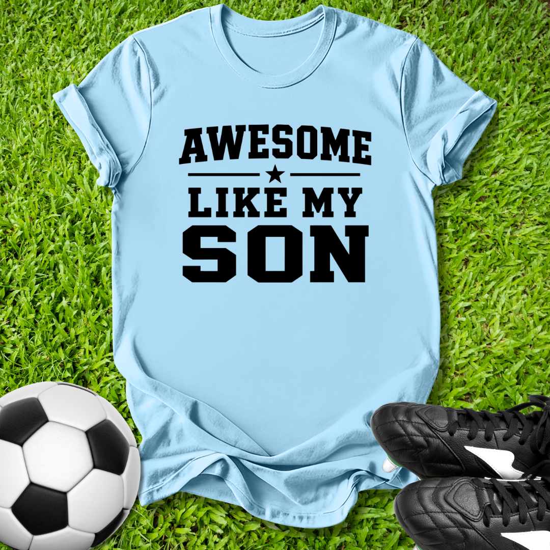 Light blue t-shirt with 'Awesome Like My Son' text on grass with soccer ball and shoes.