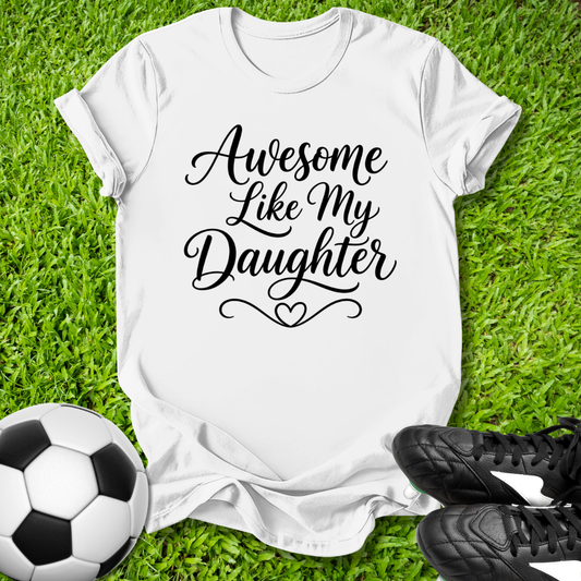 White t-shirt with 'Awesome Like My Daughter' text on grass with soccer ball and shoes