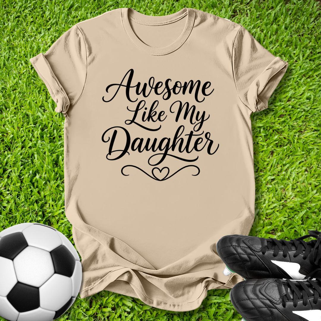 Beige t-shirt with 'Awesome Like My Daughter' text on grass with soccer ball and shoes.