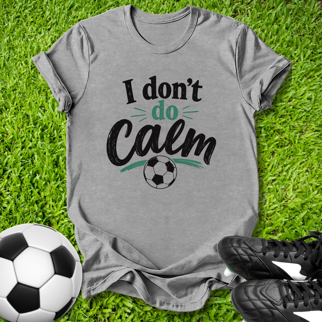 Gray t-shirt with 'I don't do Calm' text on grass with soccer ball and shoes
