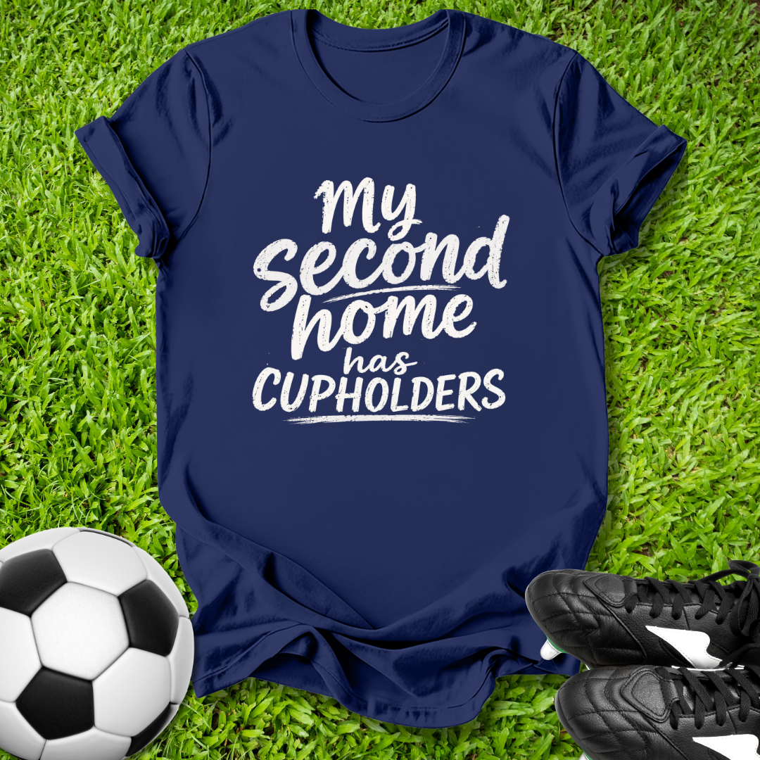 Navy blue t-shirt with 'My second home has cupholders' text on grass with soccer ball and shoes.