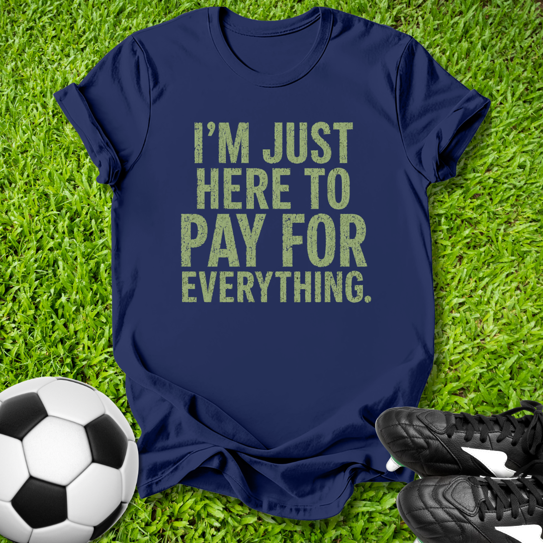 Navy blue t-shirt with humorous text on grass with soccer ball and shoes