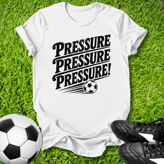 White t-shirt with 'PRESSURE PRESSURE PRESSURE!' text and soccer ball on grass with soccer ball and shoes.