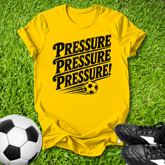 Yellow t-shirt with 'PRESSURE PRESSURE PRESSURE!' text on grass with soccer ball and shoes.