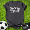 Gray t-shirt with 'Soccer Legend' text on grass with soccer ball and shoes