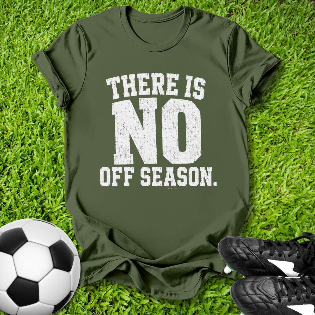 Green t-shirt with 'There is no off season' text on grass with soccer ball and shoes.