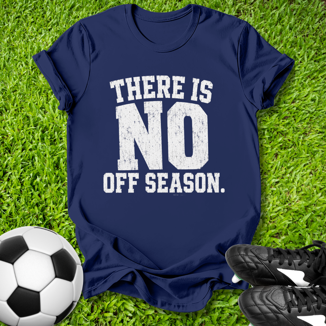 Navy blue t-shirt with 'There is no off season' text on grass with soccer ball and shoes.