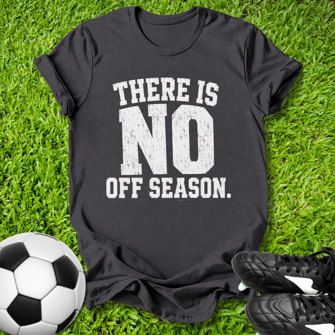 Black t-shirt with 'There is no off season' text on grass with soccer ball and shoes.