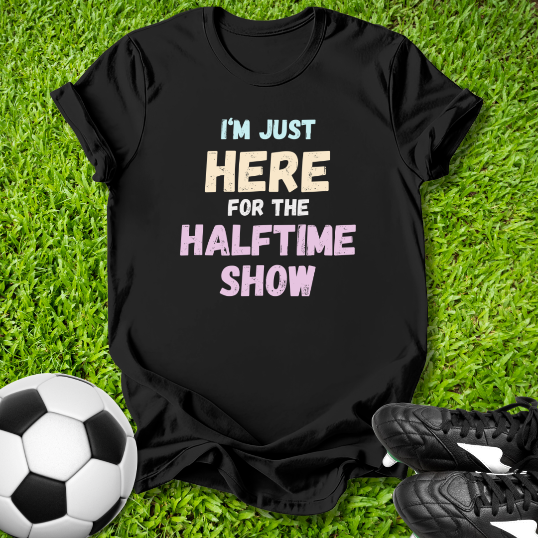 Black t-shirt with humorous text on grass with soccer ball and shoes