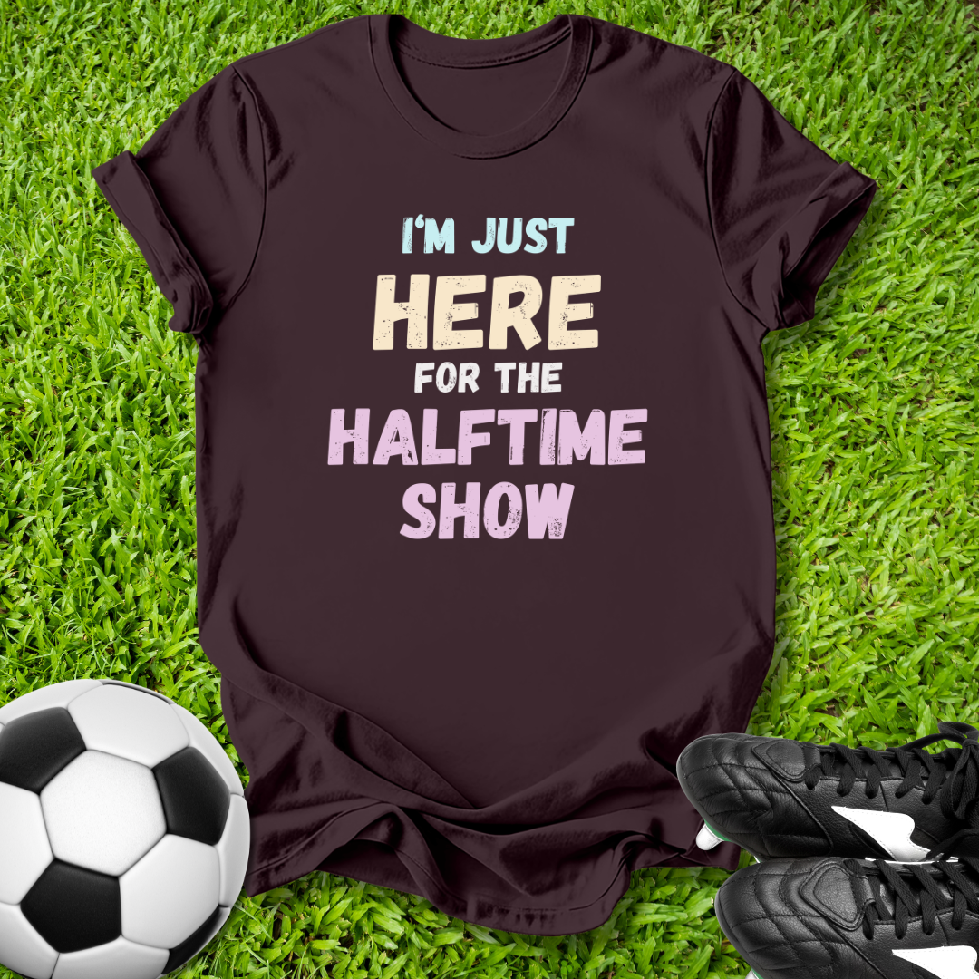Maroon t-shirt with humorous text on grass with soccer ball and shoes