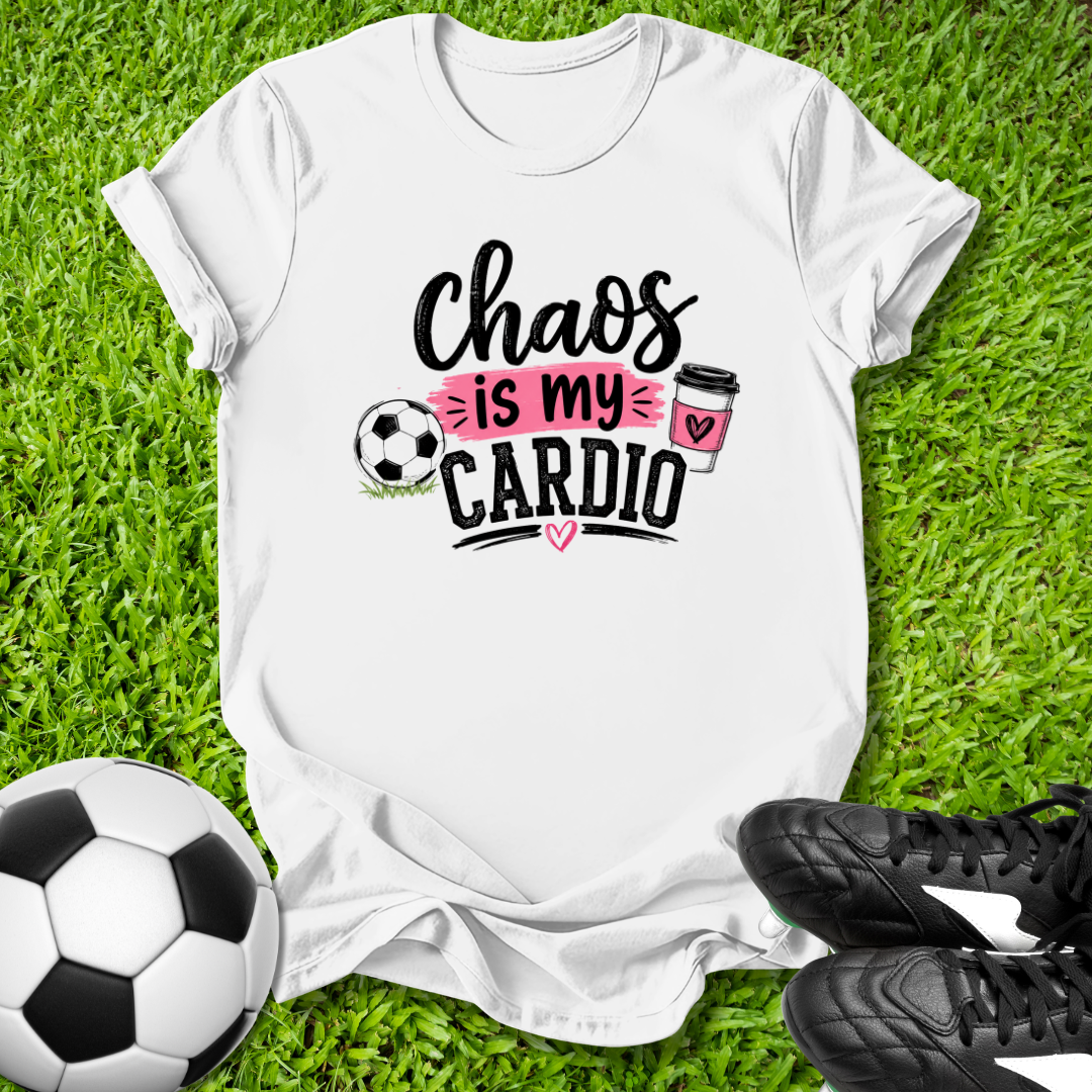 White t-shirt with 'Chaos is my Cardio' text on grass with soccer ball and shoes