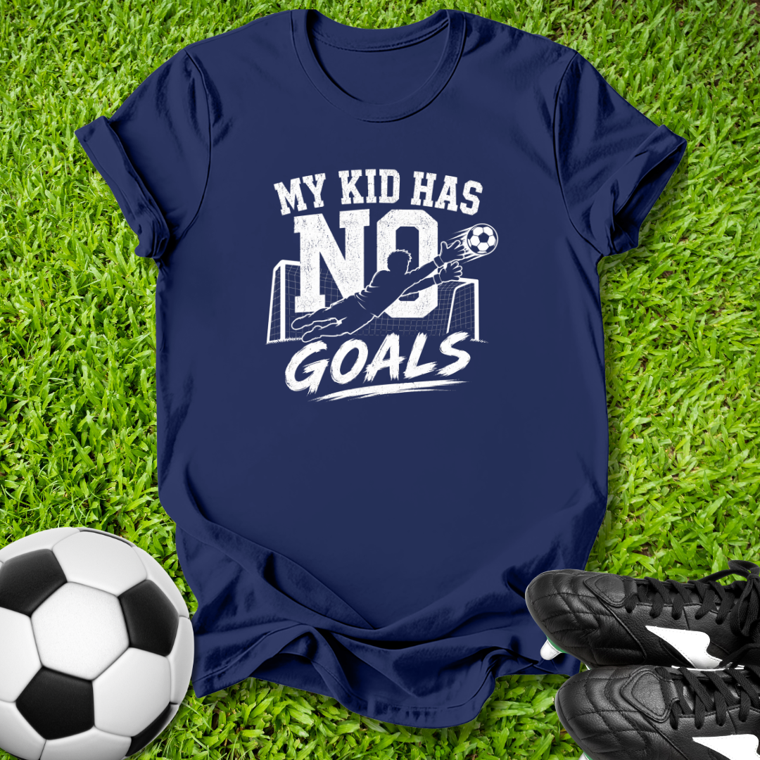 Navy blue t-shirt with 'My kid has no goals' print on grass with soccer ball and shoes.