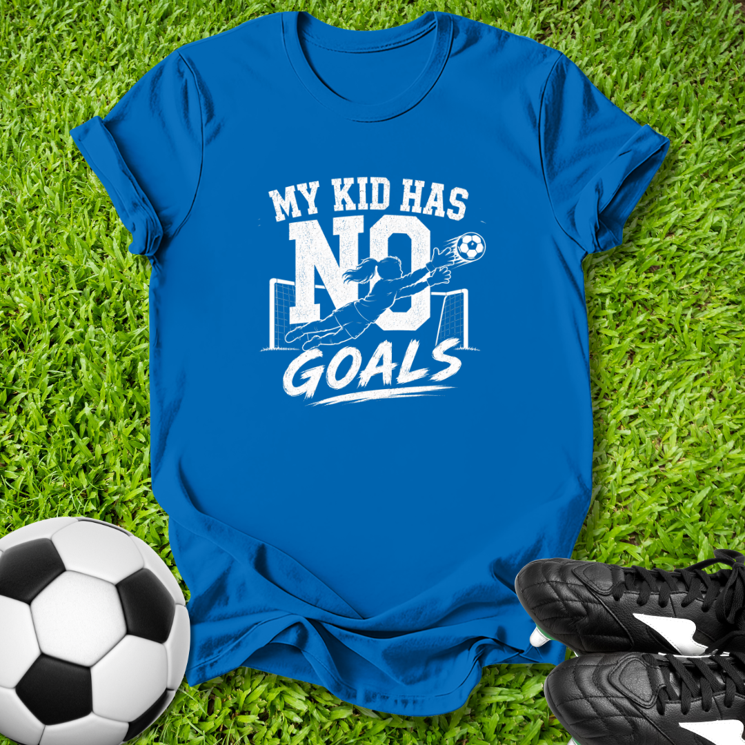 Blue t-shirt with 'My kid has no goals' print on grass with soccer ball and shoes