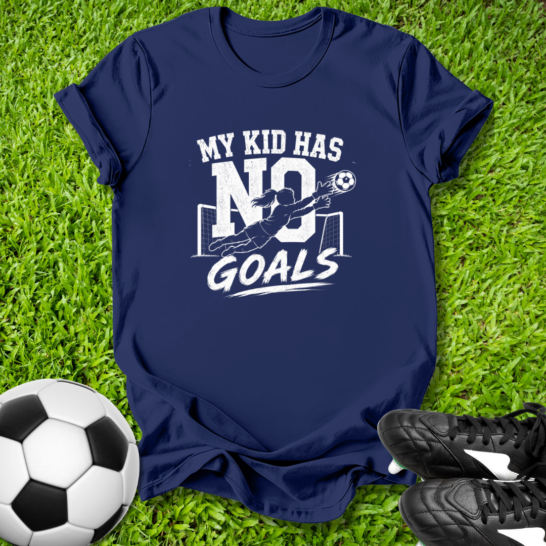 Navy blue t-shirt with 'My kid has no goals' print on grass with soccer ball and shoes.