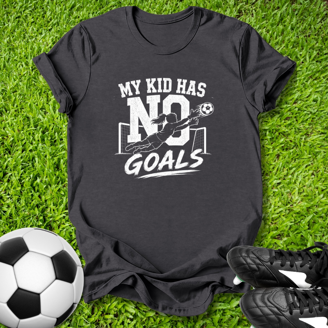 Black t-shirt with 'My kid has no goals' print on grass with soccer ball and shoes.