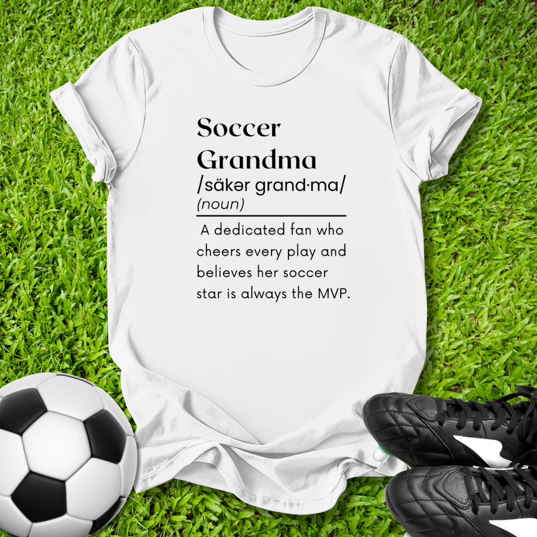 White t-shirt with 'Soccer Grandma' definition on grass with soccer ball and shoes