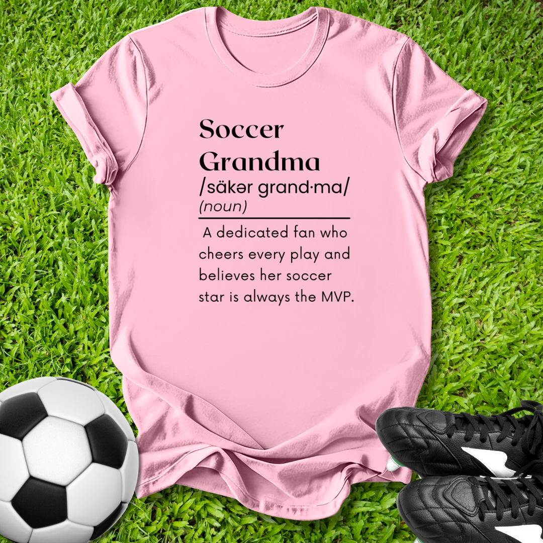 Pink t-shirt with 'Soccer Grandma' definition on grass with soccer ball and shoes