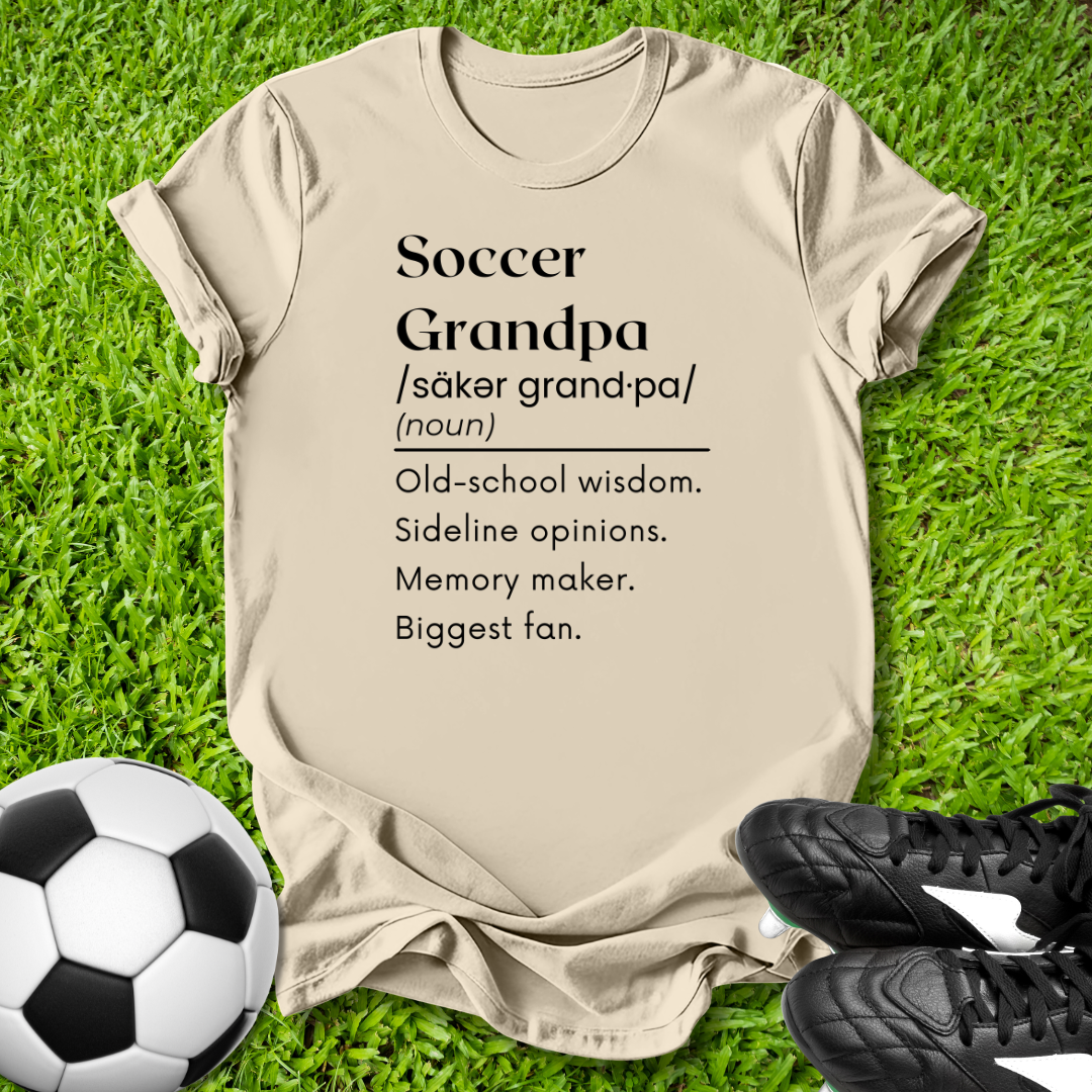 Beige t-shirt with 'Soccer Grandpa' definition on grass with soccer ball and shoes