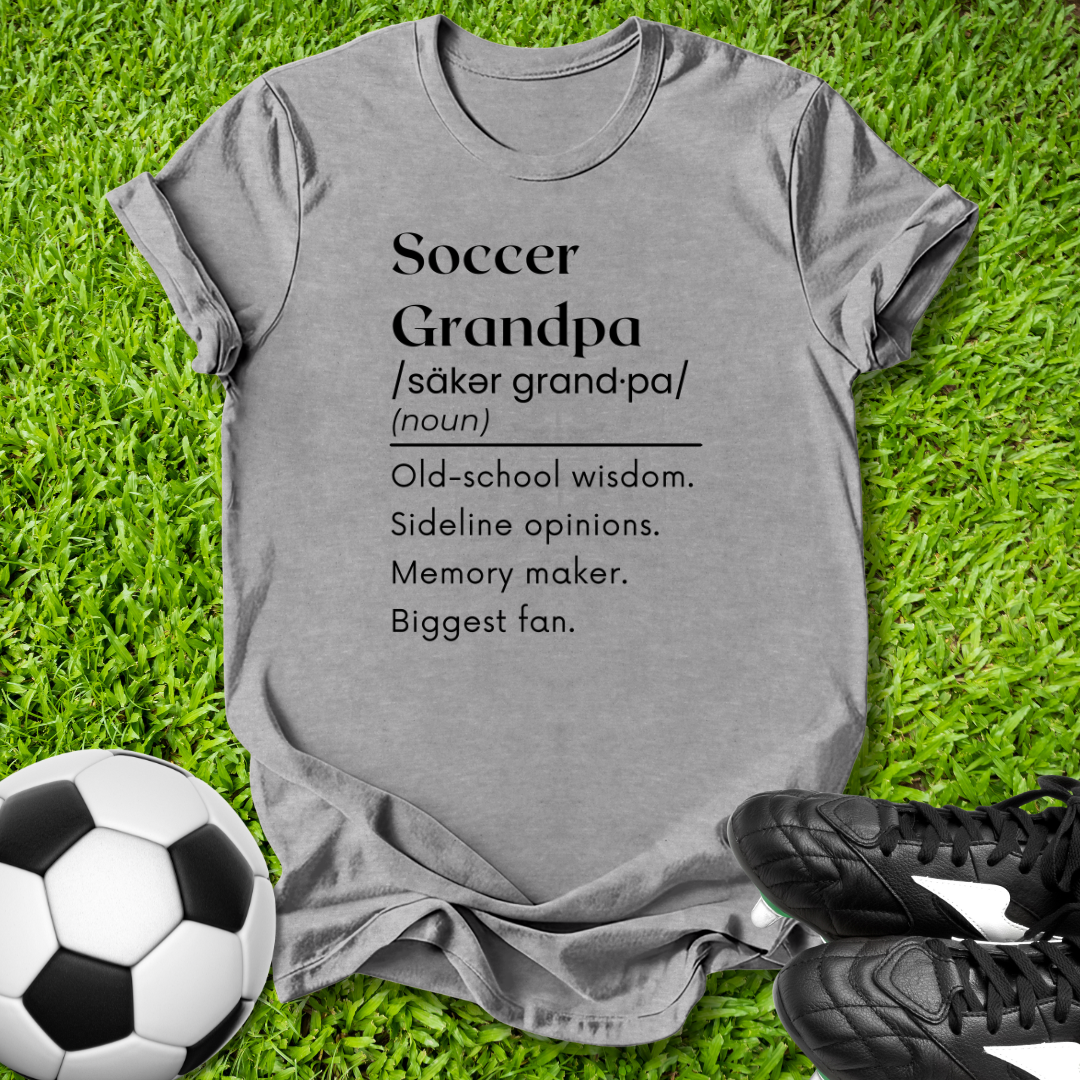 Gray t-shirt with 'Soccer Grandpa' definition on grass with soccer ball and shoes