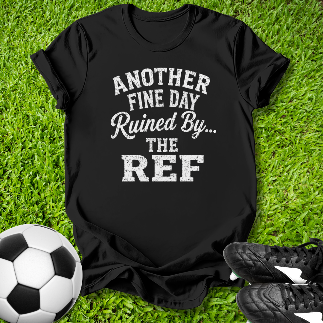 Black t-shirt with humorous text on grass with soccer ball and shoes