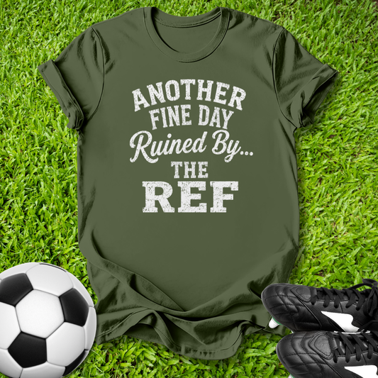 Green t-shirt with humorous text on grass with soccer ball and shoes