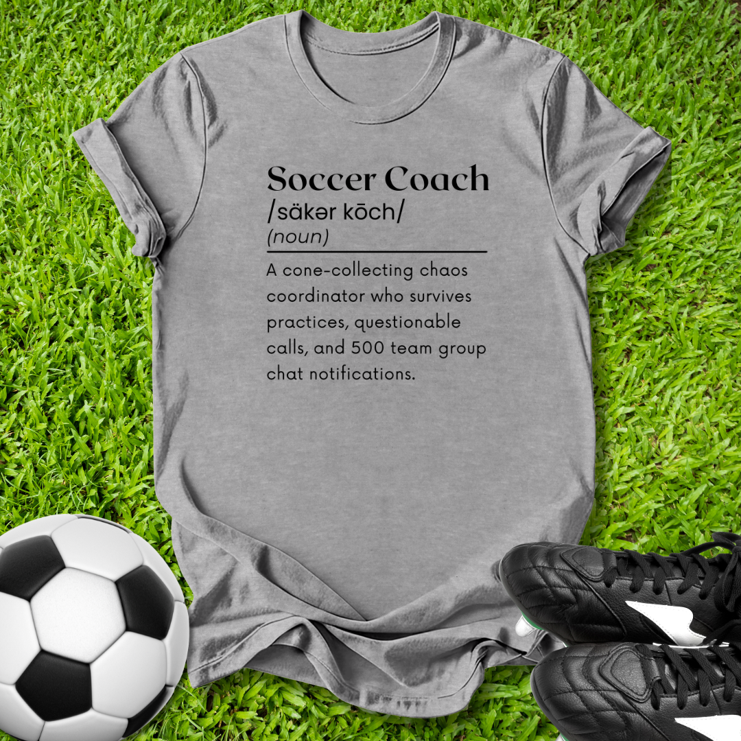 Gray t-shirt with soccer coach definition on grass with soccer ball and shoes